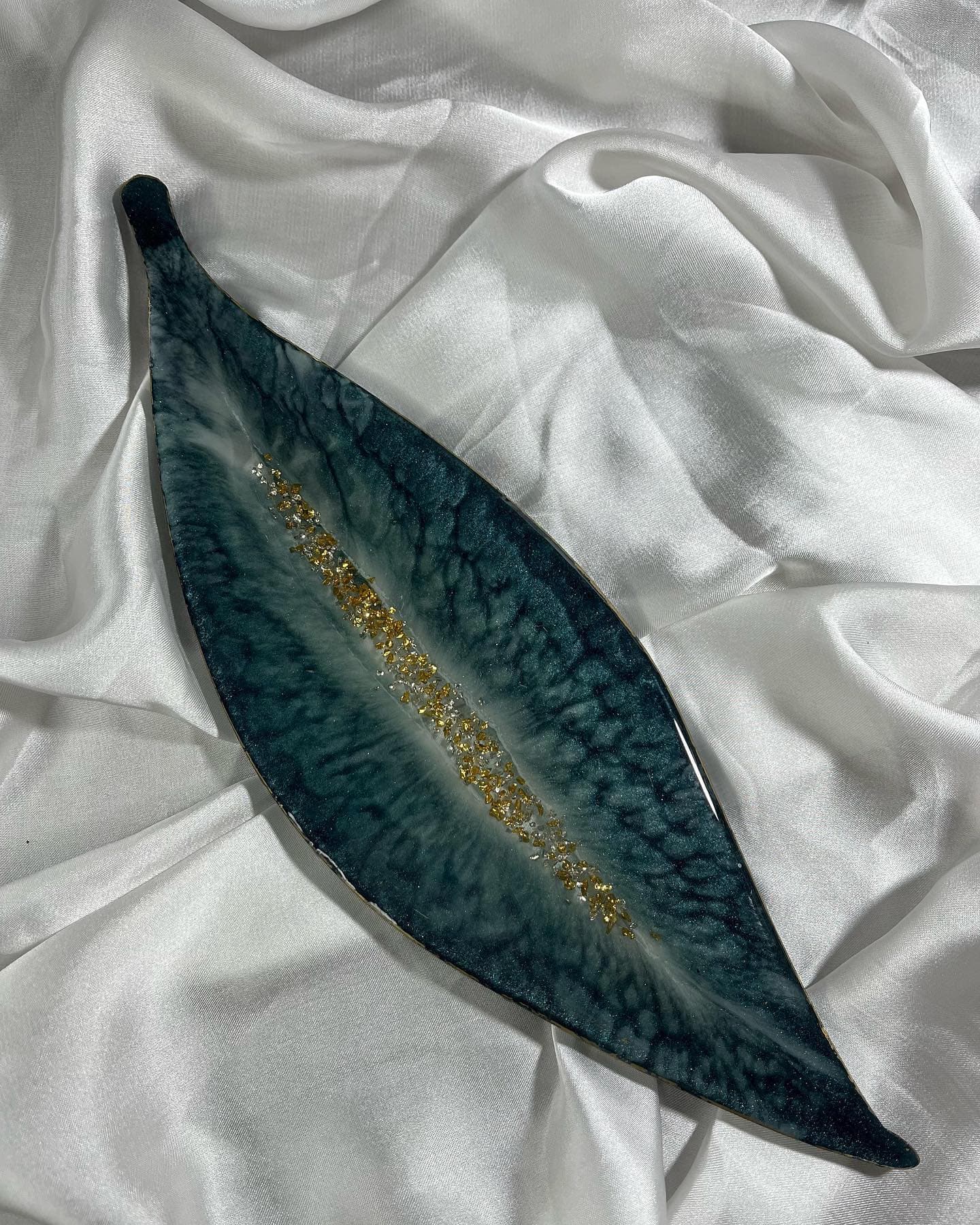 Long leaf-shaped resin platter in dark teal with a gold and silver vein running down the centre and a gilded edge